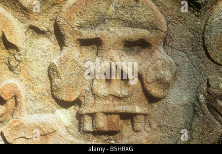 Close up di un teschio umano con alcuni denti mancanti scolpiti nella pietra tombale di arenaria Foto Stock