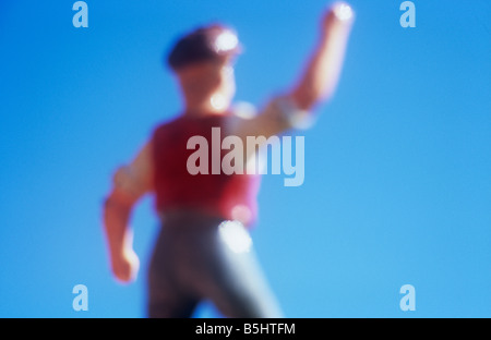 Impressionistica close up del modello di farmworker o operaio agitando il pugno e gridando rabbiosamente con cielo blu Foto Stock