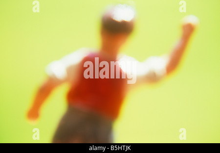 Impressionistica close up del modello di farmworker o operaio agitando il pugno e gridando rabbiosamente con erba dietro Foto Stock