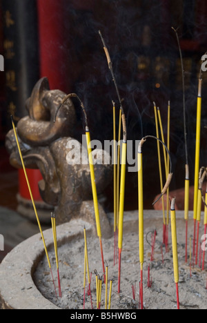 Giallo e rosso joss bastoni stand in sabbia in ettari Hoi Chuong Quan tempio nel quartiere di Cholon, Ho Chi Minh City, Vietnam Foto Stock