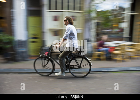 Un uomo su una bicicletta passato shop fronti di Amsterdam il quartiere Jordaan nei Paesi Bassi. Foto Stock