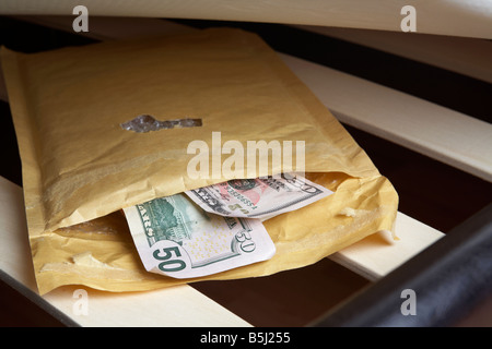 Borra di noi 50 dollar note di contanti in una busta ripiene sotto il materasso di un letto Foto Stock