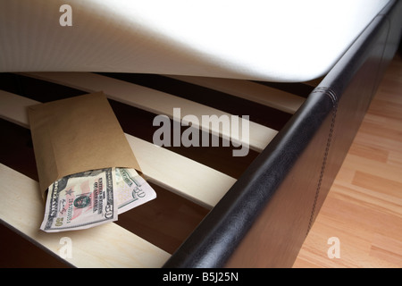 Borra di noi 50 dollar note di contanti in una busta ripiene sotto il materasso di un letto Foto Stock