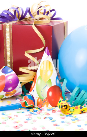 Dono, partito cappelli, corna o fischietti, confettis e palloncini su sfondo bianco. Foto Stock