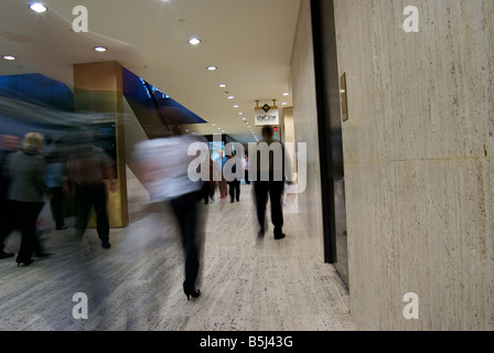 Pedoni in motion blur in pausa pranzo in motion blur scurrying attraverso la vasta galleria Downtown Loop in Houston Foto Stock