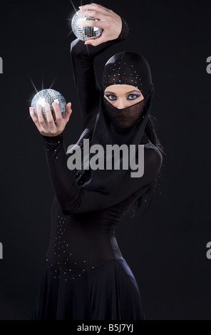 Parte ballerino in abito di ninja con sfere da discoteca Foto Stock