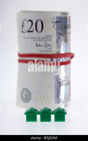 Tre case verdi sulla parte anteriore di una borra di 20 sterline banconote denaro bloccato in un rotolo con fascia elastica Foto Stock