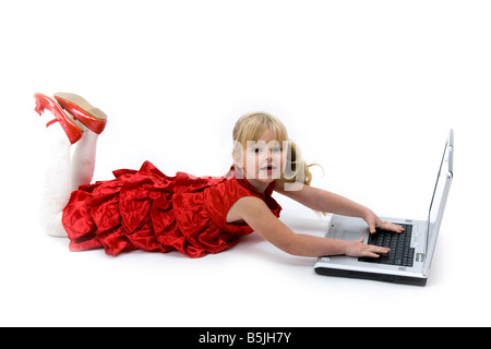 Bambino in abito rosso riproduzione o utilizzando il computer portatile dispositivo. Foto Stock