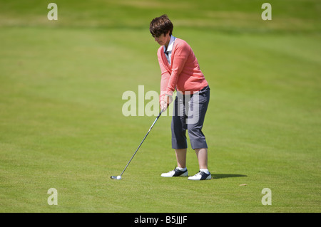 Signora basta colpire un golf shot lungo il fairway in un round di golf Foto Stock