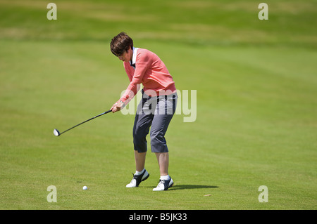 Signora basta colpire un golf shot lungo il fairway in un round di golf Foto Stock