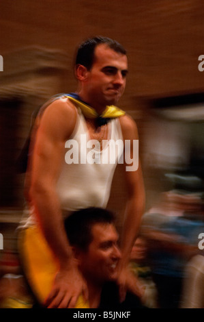 Il fantino vincente è portato aloft dalla sua contrada attraverso le strade di Siena dopo aver vinto il Palio di Siena, Italia Foto Stock