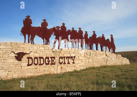 Un segno della città e la scultura all'entrata di Dodge City, Kansas, Stati Uniti d'America. Foto Stock