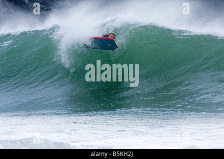 Giovane maschio surfer, Cornwall, Regno Unito con spazio intorno al soggetto per la copia o la grafica. Foto Stock