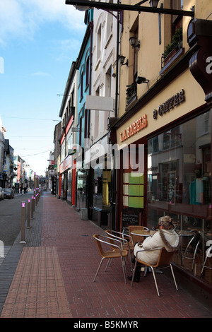 Donna con prima colazione in Oliver Plunkett Street Cork in Irlanda Foto Stock