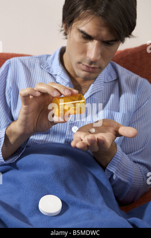 Un uomo pillole di caduta in mano Foto Stock