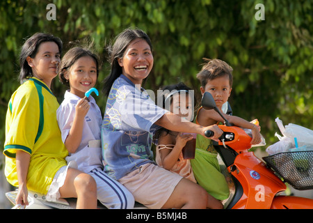 Cinque sorridenti ragazze thai in sella a una motocicletta, Khao Sok, Thailandia Foto Stock