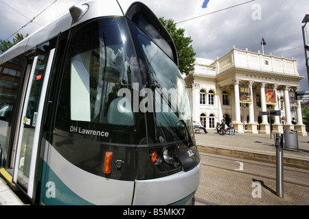 Città di Nottingham, Inghilterra. Un Nottingham Express tram in transito con il Theatre Royal, presso la piazza del teatro, in background. Foto Stock