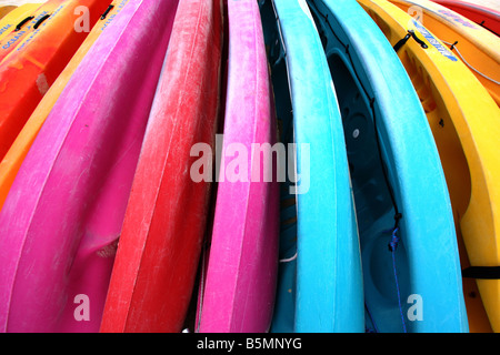 Una fila di vivacemente colorato Canoe sulla spiaggia QUEENSLAND AUSTRALIA ORIZZONTALE11161 BDA Foto Stock