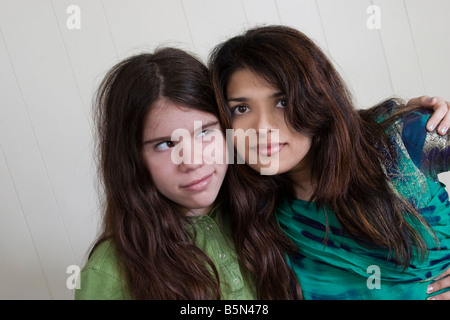 Giovane donna indiana e la sua preteen Caucasian stepsister ponendo insieme modello rilasciato Foto Stock