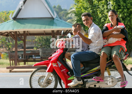 Felice e sorridente famiglia thai riding motociclo, Khao Sok, Thailandia Foto Stock