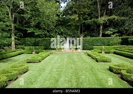 Un giardino inglese con una spruzzatura di fontana nel centro Foto Stock
