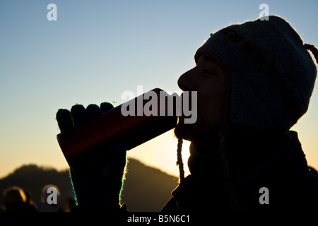 Escursionista maschio di bere da un recipiente di acqua di sunrise Foto Stock