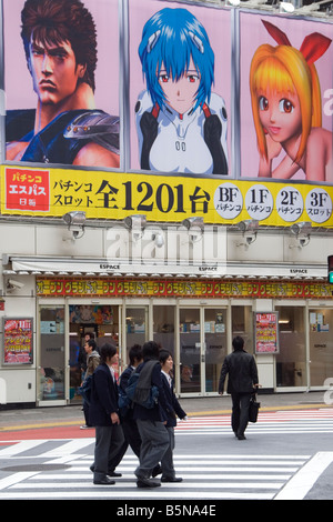 I ragazzi della scuola e pachinko parlor posters da una strada che attraversa in Shibuya Tokyo Giappone Foto Stock