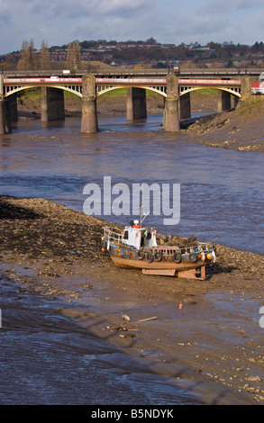 Piccola barca arenarsi utilizzati per la rimozione di rifiuti dal fango del fiume di marea Usk in Newport city centre South Wales UK Foto Stock