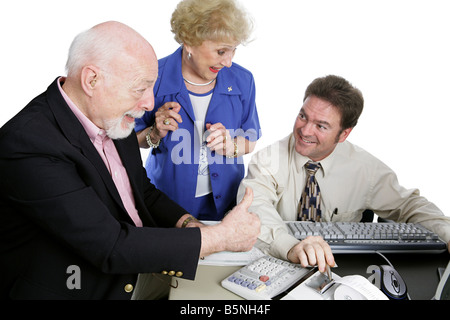 Una coppia senior dando loro ragioniere thumbsup per facendo un gran lavoro con le loro tasse isolato su bianco Foto Stock