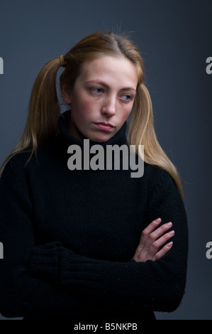 Una bionda ragazza con i capelli in pig-tail cercando moody stroppy introverso, premuto bassa riflessivo introspettivo Foto Stock