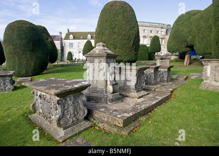 Il piedistallo e la tabella tombe tra alberi di tasso St Marys Chiesa Painswick Costwolds REGNO UNITO Foto Stock