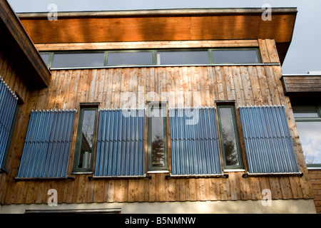 Verticalmente montato a parete solare termico tubi evacuati il negozio verde Bisley Stroud Regno Unito Foto Stock