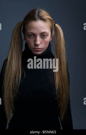 Una ragazza con i capelli in pig-tail cercando moody stroppy introverso Foto Stock