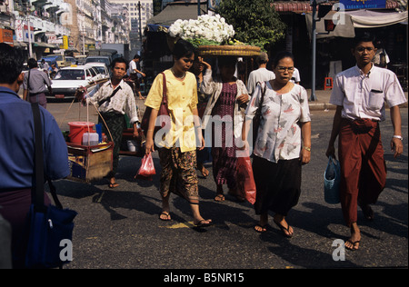 Di birmani pedoni che attraversano una strada durante le ore di punta nel centro di Rangoon o Yangon, Birmania o Myanmar Foto Stock