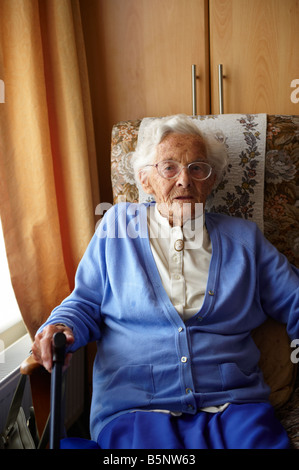 Signora anziana seduto nella sedia dalla finestra in casa di riposo Foto Stock