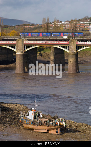 Piccola barca arenarsi utilizzati per la rimozione di rifiuti dal fango del fiume di marea Usk in Newport Town Center South Wales UK Foto Stock