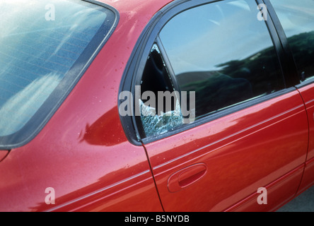 Rotto il vetro laterale posteriore di auto rossa Foto Stock