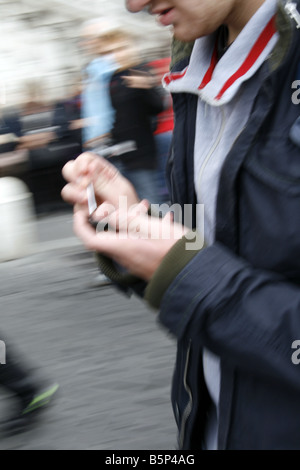 Giovane uomo utilizzando Palmare Palm PC computer in Street nella città della città Foto Stock