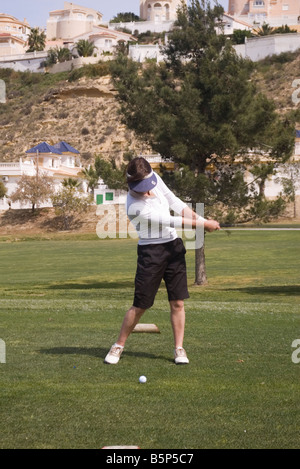 Signora donna femmina golfista amatoriale giocando prendendo un swing di pratica presso la Marchesa Golf e Country Club Quesada Spagna Foto Stock