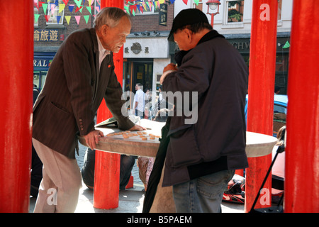 Gli uomini cinesi il gioco del gioco di bozze in Londra Chinatown Foto Stock