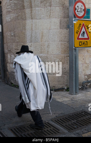 Israele Gerusalemme vecchia città ebreo ortodosso coperto con la preghiera scialle e camminata veloce in strada Foto Stock