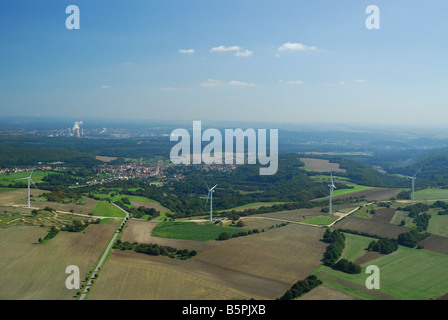 Ampia vista aerea di centrali eoliche di turbine eoliche con sullo sfondo il carbone centrali elettriche Foto Stock