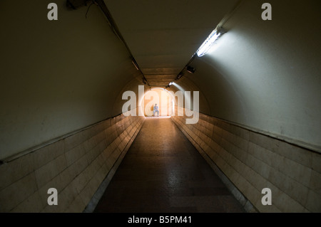 Uomo seduto dentro la zona pedonale di tunnel sotterraneo sotto la strada vicino al Bazaar di Khan El Khalili Cairo Egitto Foto Stock