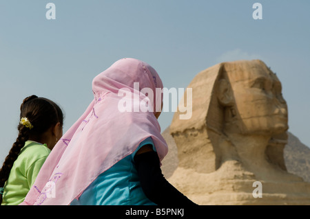Le ragazze egiziane guardano la Grande Sfinge di Giza, che si ritiene sia stata costruita dagli antichi egiziani del Vecchio Regno Egitto Foto Stock