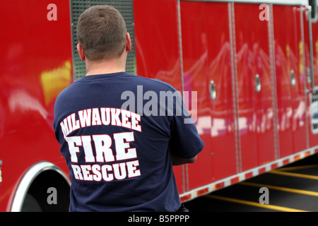 Il personale per il Milwaukee Fire Rescue T shirt in piedi di fronte a un fuoco di Milwaukee Wisconsin veicolo Foto Stock