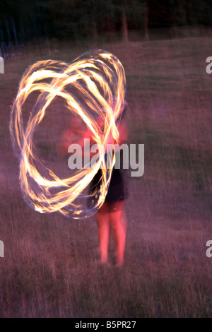 Il bagliore di una femmina di Hawaiian Fire ballerina di eseguire durante la notte Foto Stock