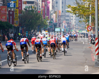 I ciclisti nel peloton ride passato la folla, Tour de Taiwan fase 1 crtierium, Kaohsiung, Taiwan, ROC Foto Stock