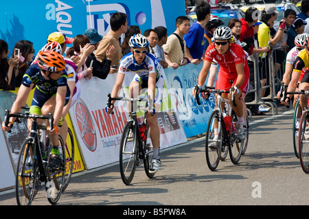 I ciclisti nel peloton ride passato la folla, Tour de Taiwan fase 1 crtierium, Kaohsiung, Taiwan, ROC Foto Stock