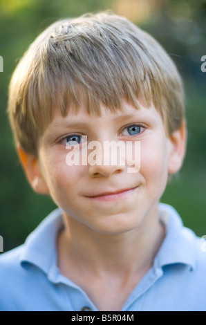 Blu brillante eyed bambino di otto anni nel giardino inglese durante il periodo estivo Foto Stock