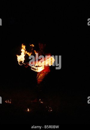 Il bagliore di un fuoco di Hawaiian ballerina di eseguire durante la notte Foto Stock